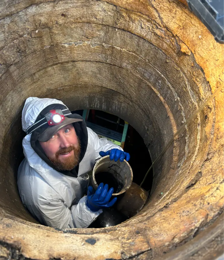 A plumber stooped inside of a well
