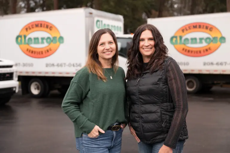 The glenrose team, smiling wiht their work trucks in the background