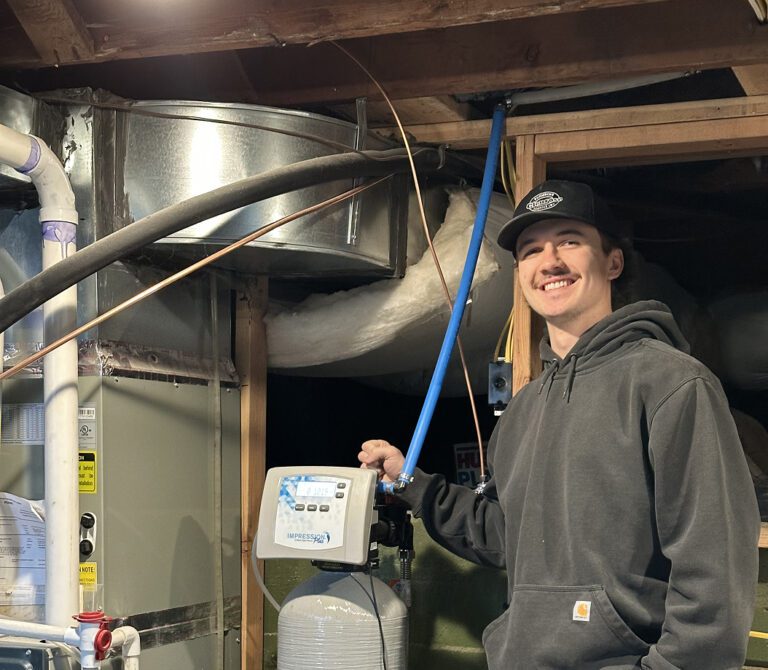 A Glenrose plumber beside a newly installed water softener